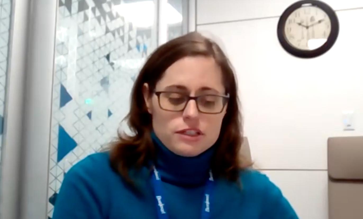 Breagh MacLean talks to a webcame. She has shoulder length brown hair