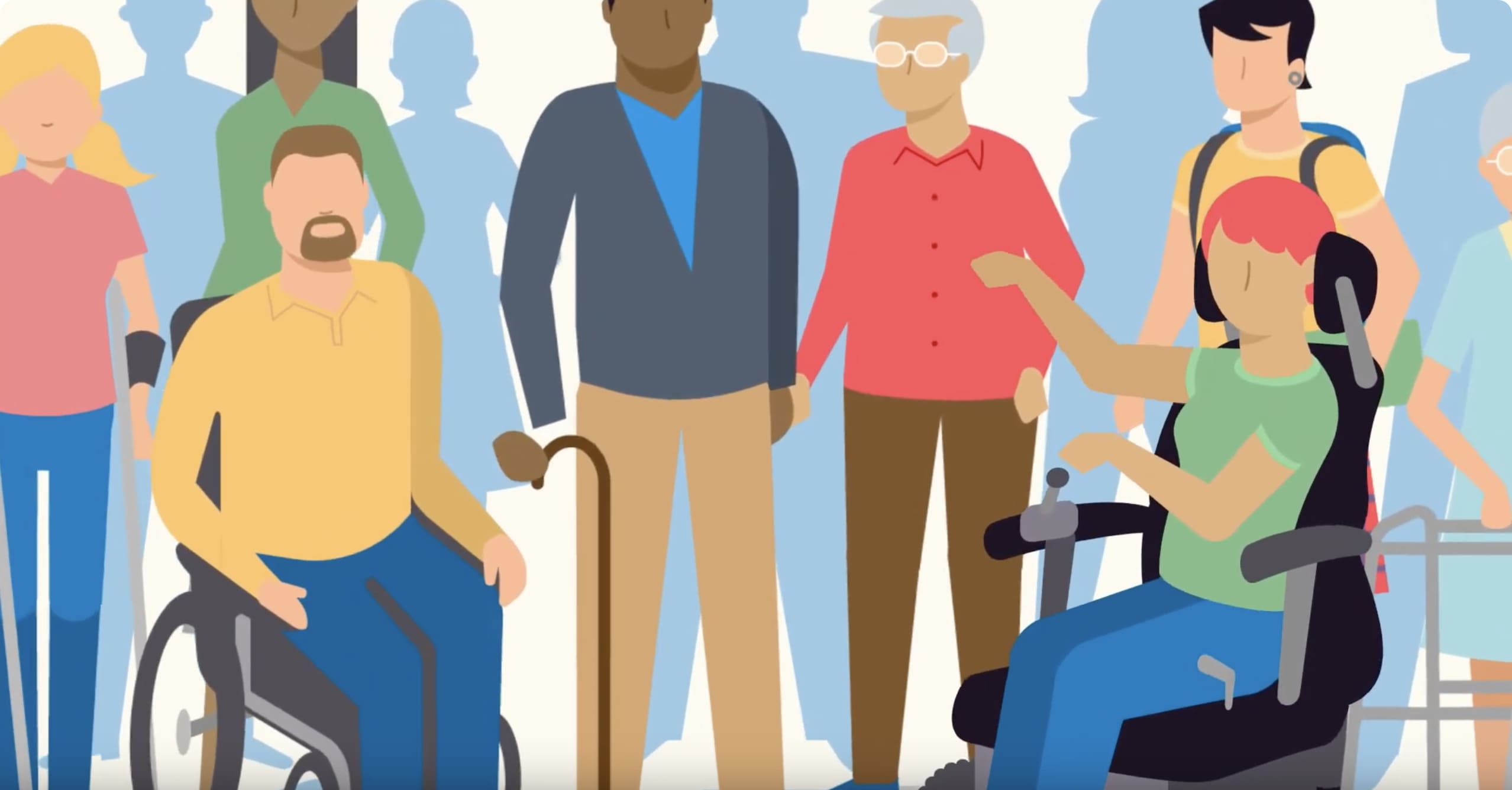 Photo of a group of people that are sitting and standing next to each other. One person is in a wheelchair